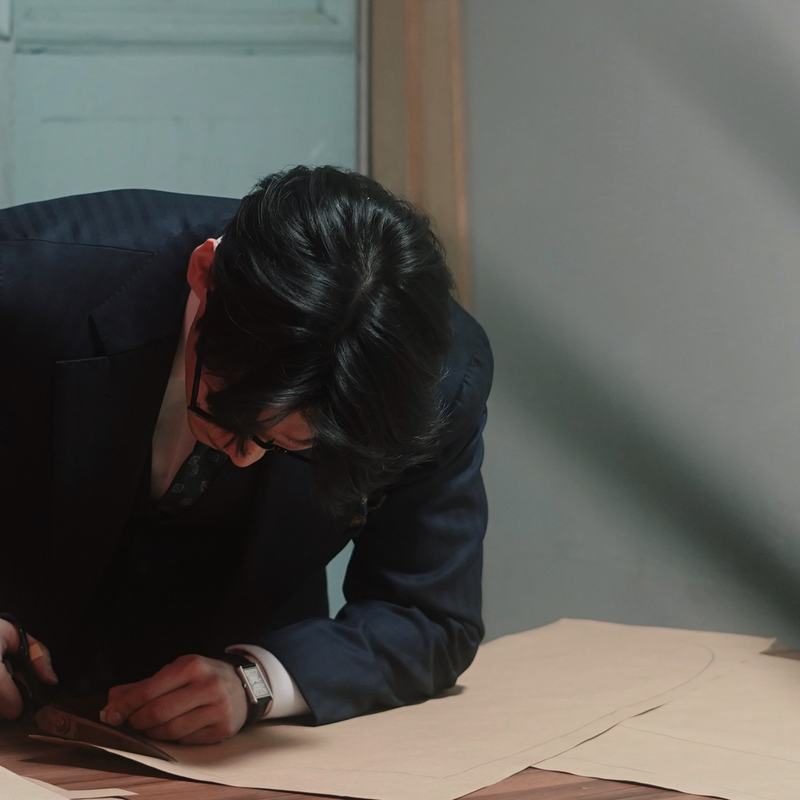 A tailor cutting a paper pattern